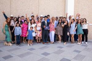 A family surrounds their graduate at the spring 2024 commencement.